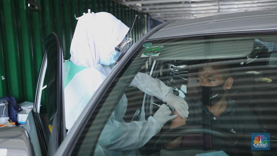 Petugas kesehatan menyuntikkan vaksin dosis pertama kepada driver Gojek di Kemayoran, Jakarta, Kamis (29/4/2021). Halodoc dan Gojek berkolaborasi hadirkan pos pelayanan Covid-19 melalui metode Drive thru dan melayani 1.500 dosis vaksin setiap harinya untuk memperkuat upaya Kementerian Kesehatan RI dalam mempercepat Vaksinasi Covid-19 di Indonesia.  (CNBC Indonesia/ Tri Susilo)