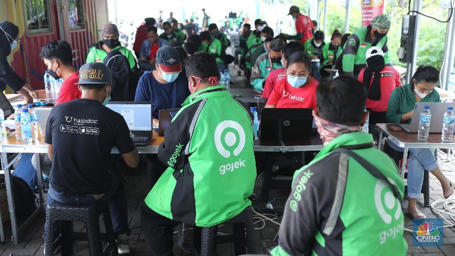 Petugas kesehatan menyuntikkan vaksin dosis pertama kepada driver Gojek di Kemayoran, Jakarta, Kamis (29/4/2021). Halodoc dan Gojek berkolaborasi hadirkan pos pelayanan Covid-19 melalui metode Drive thru dan melayani 1.500 dosis vaksin setiap harinya untuk memperkuat upaya Kementerian Kesehatan RI dalam mempercepat Vaksinasi Covid-19 di Indonesia.  (CNBC Indonesia/ Tri Susilo)