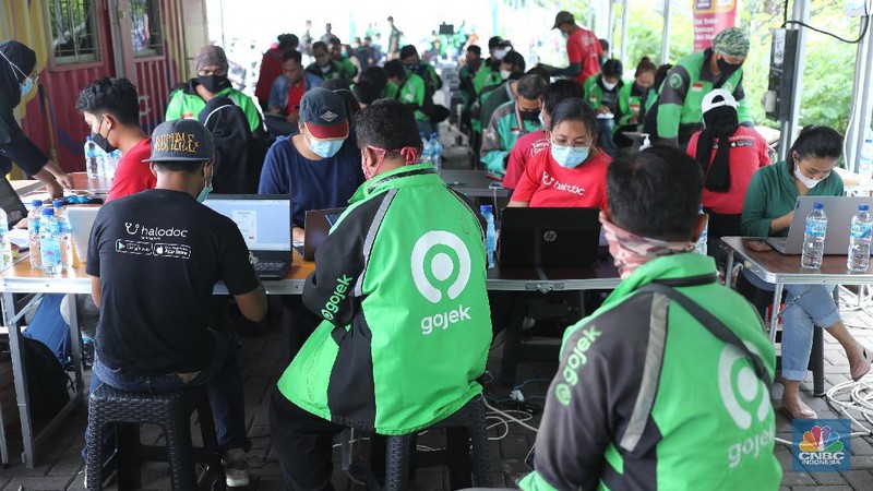Petugas kesehatan menyuntikkan vaksin dosis pertama kepada driver Gojek di Kemayoran, Jakarta, Kamis (29/4/2021). Halodoc dan Gojek berkolaborasi hadirkan pos pelayanan Covid-19 melalui metode Drive thru dan melayani 1.500 dosis vaksin setiap harinya untuk memperkuat upaya Kementerian Kesehatan RI dalam mempercepat Vaksinasi Covid-19 di Indonesia.  (CNBC Indonesia/ Tri Susilo)