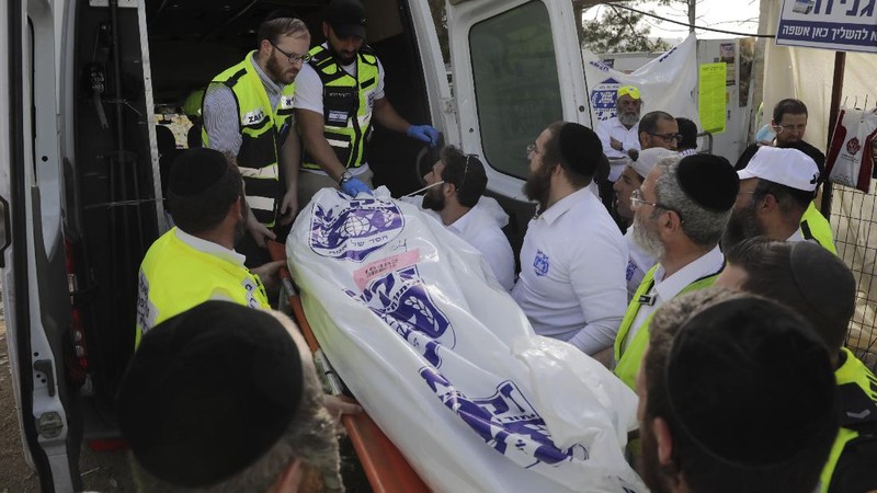 Israeli security officials and rescuers carry a body of a victim who died during a Lag Ba'Omer celebrations at Mt. Meron in northern Israel, Friday, April 30, 2021. More than 100 people were injured, dozens critically, in a stampede at a Jewish religious gathering in northern Israel attended by tens of thousands of people, Israel's main rescue service said early Friday. (AP Photo)