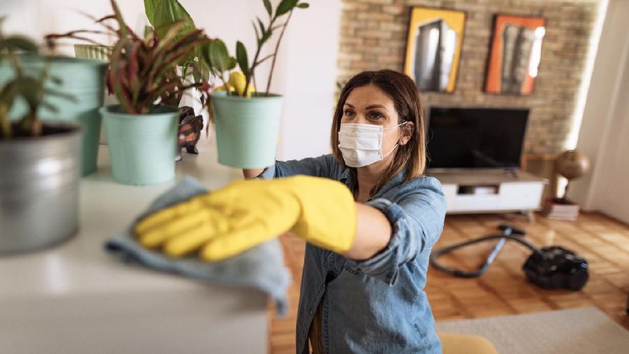 Woman working at home, cleaning the floors, washing the laundry and cleaning up the mess in the closet during quarantine