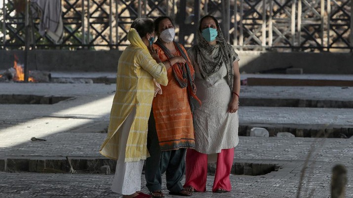 krematorium di India Relative of a person who died due to COVID-19 reacts during cremation in Jammu, India, Monday, April 26, 2021. (AP Photo/Channi Anand)