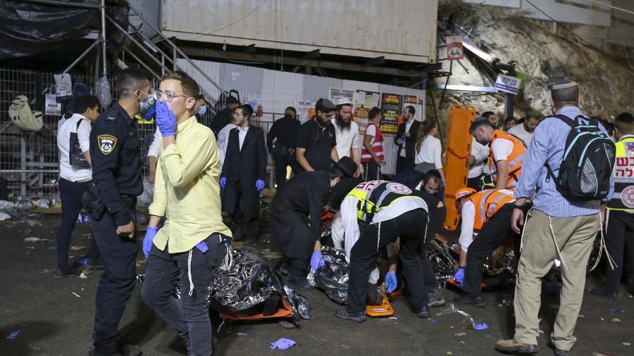Israeli security officials and rescuers carry a body of a victim who died during a Lag Ba'Omer celebrations at Mt. Meron in northern Israel, Friday, April 30, 2021. More than 100 people were injured, dozens critically, in a stampede at a Jewish religious gathering in northern Israel attended by tens of thousands of people, Israel's main rescue service said early Friday. (AP Photo)
