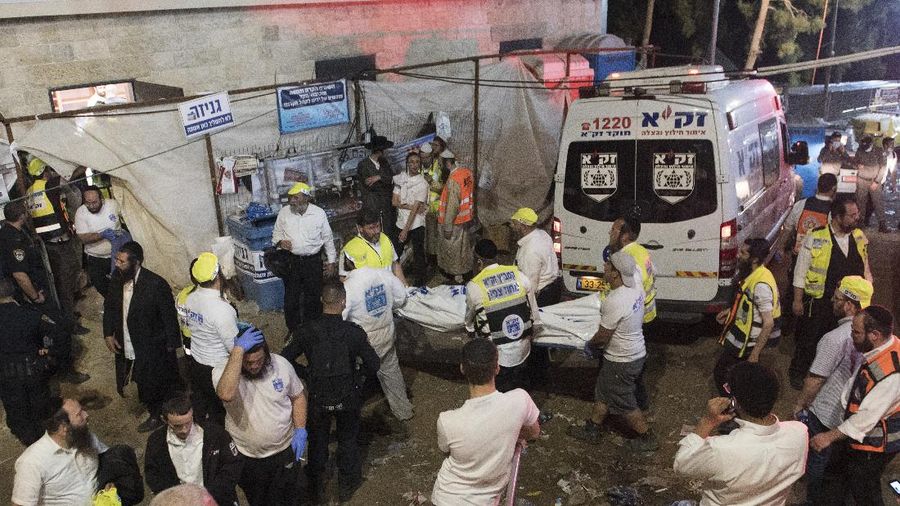 Israeli security officials and rescuers carry a body of a victim who died during a Lag Ba'Omer celebrations at Mt. Meron in northern Israel, Friday, April 30, 2021. More than 100 people were injured, dozens critically, in a stampede at a Jewish religious gathering in northern Israel attended by tens of thousands of people, Israel's main rescue service said early Friday. (AP Photo)