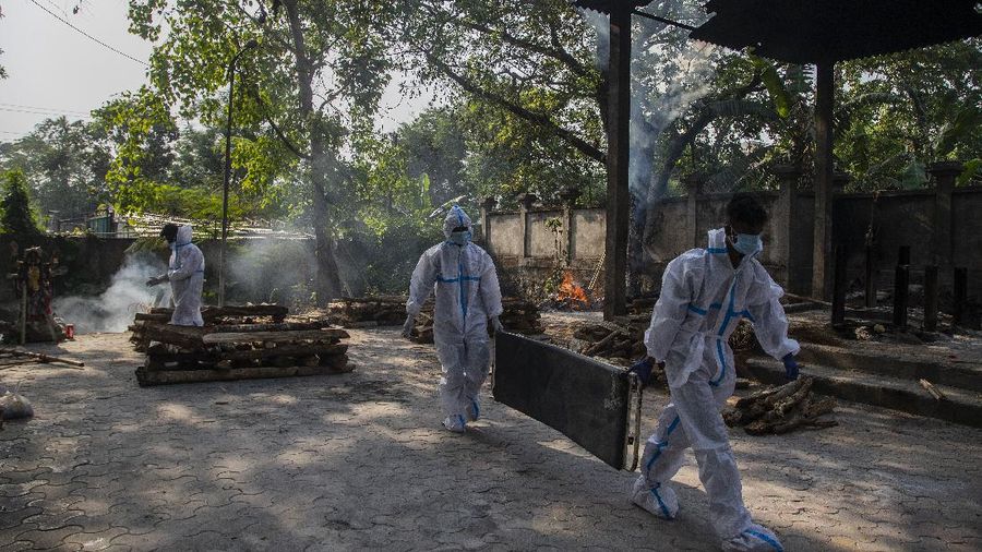 Indian health workers in protective suit return after bringing the body of a person who died of COVID-19 for cremation in Gauhati, India, Tuesday, April 27, 2021. The COVID-19 death toll in India has topped 200,000 as the country endures its darkest chapter of the pandemic yet. (AP Photo/Anupam Nath)