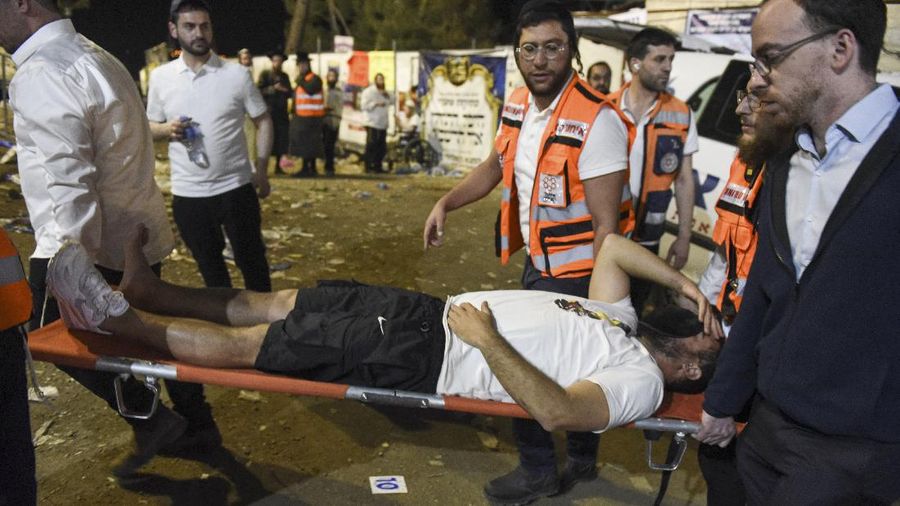 Israeli security officials and rescuers carry a body of a victim who died during a Lag Ba'Omer celebrations at Mt. Meron in northern Israel, Friday, April 30, 2021. More than 100 people were injured, dozens critically, in a stampede at a Jewish religious gathering in northern Israel attended by tens of thousands of people, Israel's main rescue service said early Friday. (AP Photo)