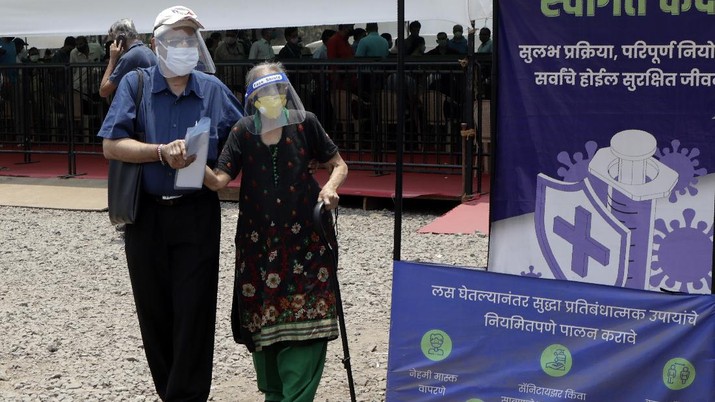 vaksinasi di india People wearing face shields and masks as a precaution against the coronavirus arrive to receive COVID-19 vaccine in Mumbai, India, Thursday, April 29, 2021. India set another global record in new virus cases Thursday, as millions of people in one state cast votes despite rising infections and the country geared up to open its vaccination rollout to all adults amid snags. (AP Photo/Rajanish Kakade)