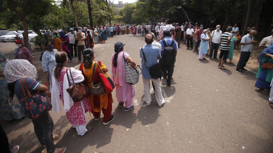 People queue up for COVID-19 vaccine in Mumbai, India, Monday, April 26, 2021. New infections are rising faster in India than any other place in the world, stunning authorities and capsizing its fragile health system. (AP Photo/Rafiq Maqbool)