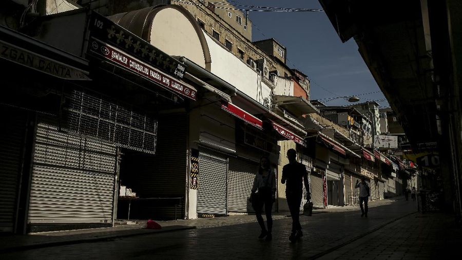 A man walks on deserted Eminonu market with shops closed, Friday, April 30, 2021, on the first day of a tight lockdown to help protect from the spread of the coronavirus. Turkish President Recep Tayyip Erdogan imposed the new lockdown restrictions that will last until May 17, after COVID-19 infections and fatalities hit record high levels. Under the restrictions -- which spans the holy Muslim month of Ramadan, as well as the three-day Eid holiday - residents are banned from leaving their homes except to shop for groceries or to meet other essential needs.(AP Photo/Emrah Gurel)