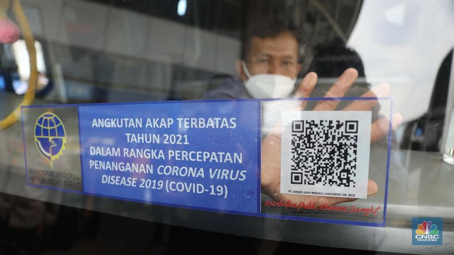 Penempelan stiker di Terminal bus  Pulogebang. (CNBC Indonesia/Muhammaad Sabki)
