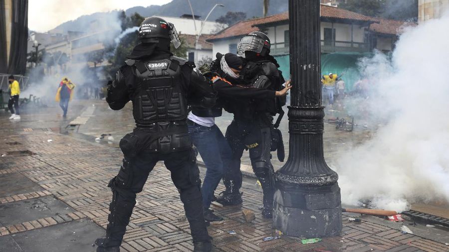 Bentrokan terjadi antara massa aksi protes reformasi pajak dengan aparat keamanan di Kolombia. (AP/Fernando Vergara)