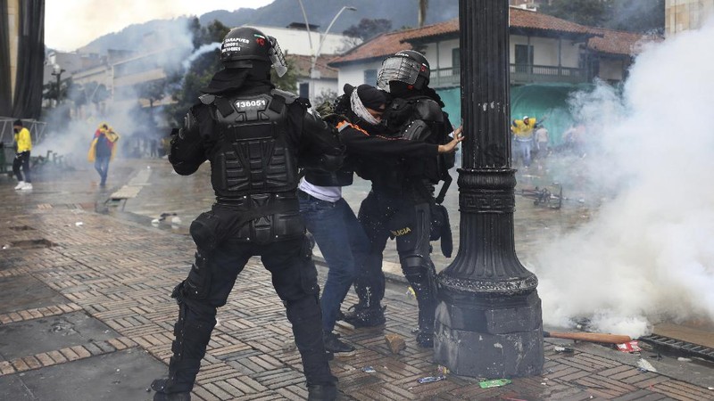 Bentrokan terjadi antara massa aksi protes reformasi pajak dengan aparat keamanan di Kolombia. (AP/Fernando Vergara)