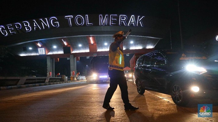 Petugas kepolisian memeriksa dokumen pengendara yang melintas dari arah Jakarta menuju Merak di pintu Gerbang Tol Merak, Banten, Kamis (6/5/2021) dini hari. Pemeriksaan tersebut terkait larangan mudik lebaran 2021 yang dimulai dari tanggal 6 hingga 17 Mei sebagai upaya mengantisipasi risiko peningkatan kasus penularan COVID-19 jelang perayaan Hari Raya Idul Fitri 1442 H. (CNBC Indonesia/Andrean Kristianto)