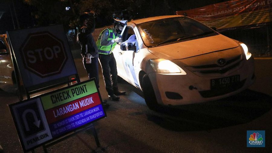 Petugas kepolisian memeriksa dokumen pengendara yang melintas dari arah Jakarta menuju Merak di pintu Gerbang Tol Merak, Banten, Kamis (6/5/2021) dini hari. Pemeriksaan tersebut terkait larangan mudik lebaran 2021 yang dimulai dari tanggal 6 hingga 17 Mei sebagai upaya mengantisipasi risiko peningkatan kasus penularan COVID-19 jelang perayaan Hari Raya Idul Fitri 1442 H. (CNBC Indonesia/Andrean Kristianto)