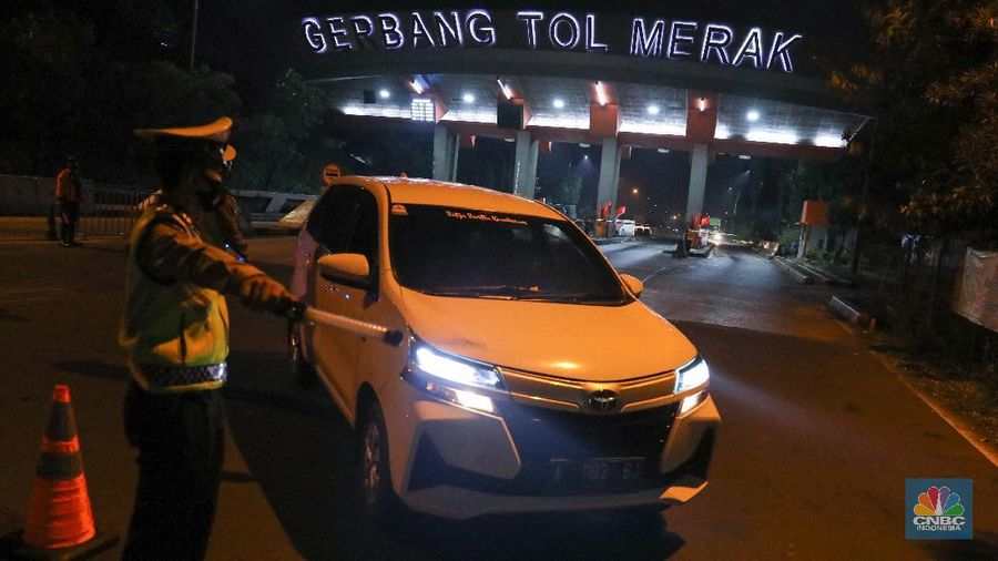Petugas kepolisian memeriksa dokumen pengendara yang melintas dari arah Jakarta menuju Merak di pintu Gerbang Tol Merak, Banten, Kamis (6/5/2021) dini hari. Pemeriksaan tersebut terkait larangan mudik lebaran 2021 yang dimulai dari tanggal 6 hingga 17 Mei sebagai upaya mengantisipasi risiko peningkatan kasus penularan COVID-19 jelang perayaan Hari Raya Idul Fitri 1442 H. (CNBC Indonesia/Andrean Kristianto)