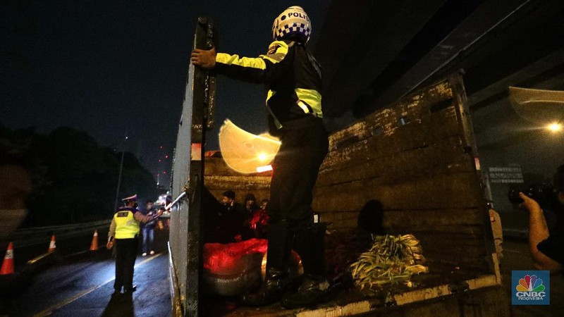 Warga nekat mudik dibalik truk sayur. (CNBC Indonesia/Muhammad Sabki)
