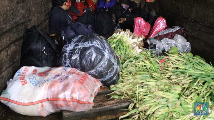 Warga nekat mudik dibalik truk sayur. (CNBC Indonesia/Muhammad Sabki)