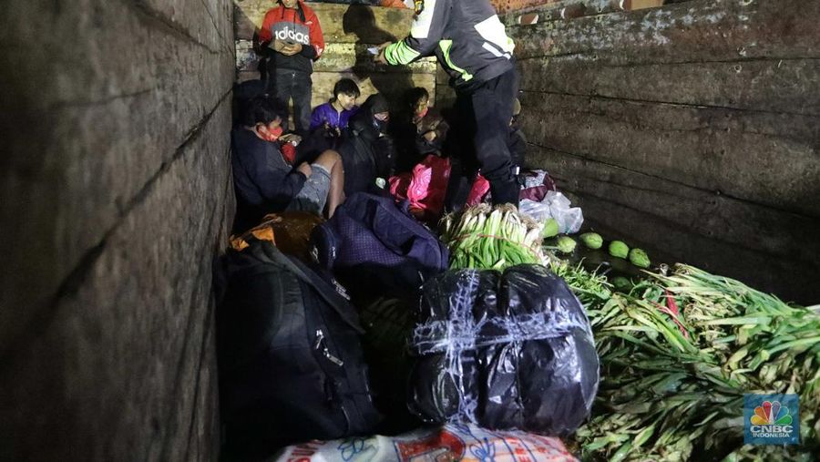 Warga nekat mudik dibalik truk sayur. (CNBC Indonesia/Muhammad Sabki)