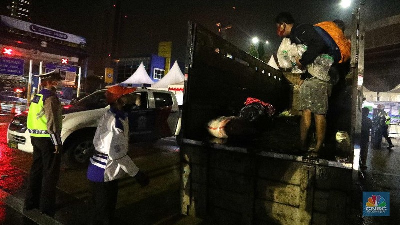 Warga nekat mudik dibalik truk sayur. (CNBC Indonesia/Muhammad Sabki)