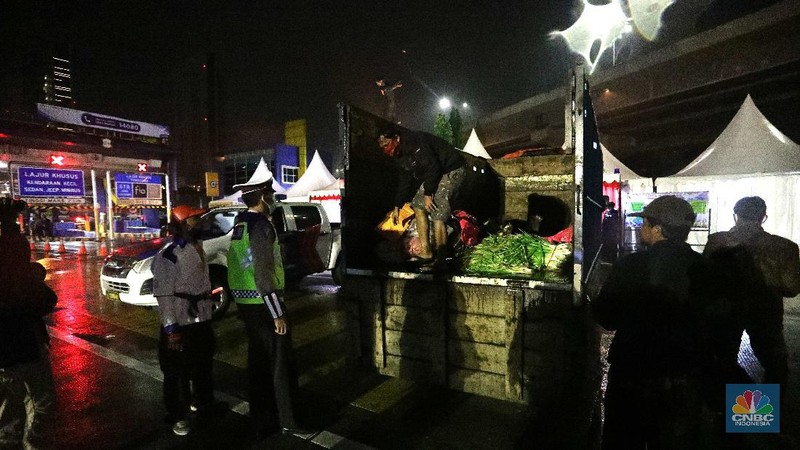 Warga nekat mudik dibalik truk sayur. (CNBC Indonesia/Muhammad Sabki)