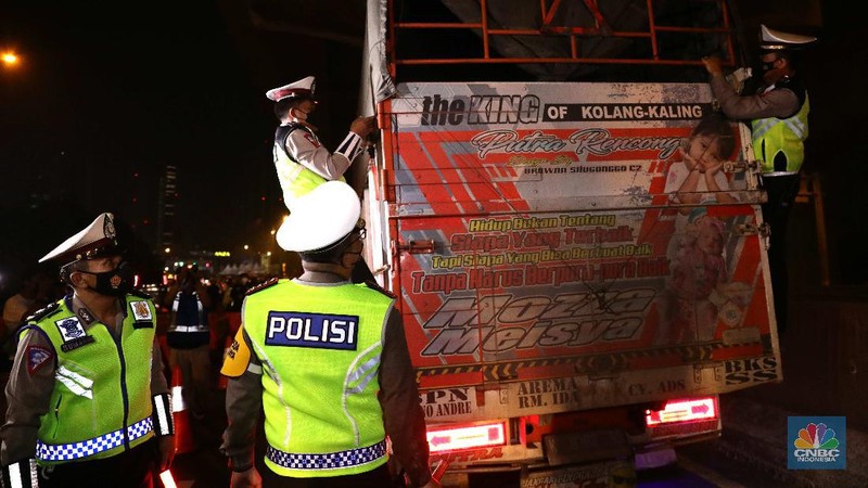 Warga nekat mudik dibalik truk sayur. (CNBC Indonesia/Muhammad Sabki)