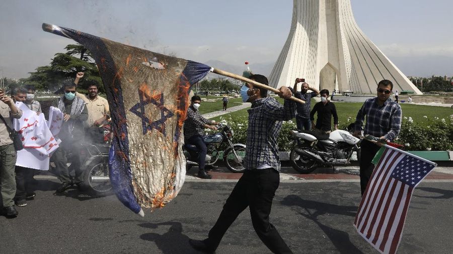 Demonstrators burn representations of Israeli and U.S flags during the annual Al-Quds, or Jerusalem, Day rally, with the Azadi (Freedom) monument tower seen at right, in Tehran, Iran, Friday, May 7, 2021. Iran held a limited anti-Israeli rally amid the coronavirus pandemic to mark the Quds Day. After the late Ayatollah Khomeini, leader of the Islamic Revolution and founder of present-day Iran, toppled the pro-Western Shah in 1979, he declared the last Friday of the Muslim holy month of Ramadan as an international day of struggle against Israel and for the liberation of Jerusalem. (AP Photo/Vahid Salemi)