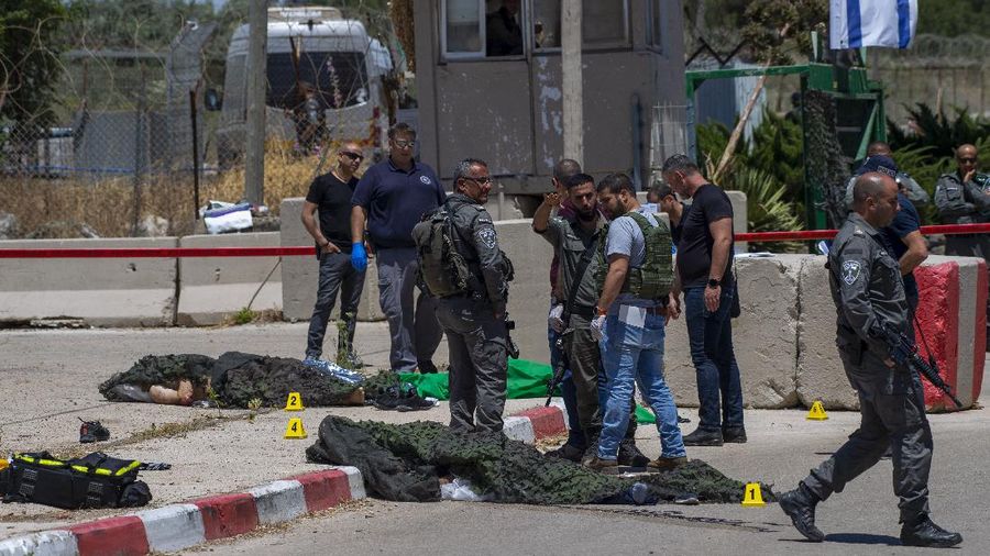 Israeli forces inspect the scene of a shooting attack where bodies of two Palestinian gunmen, killed by Israeli border police, lie on the ground in front of the military base of Salem near the West Bank town of Jenin, Friday, May. 7, 2021. Israeli troops shot and killed the two men and wounded a third after they opened fire on a border police base in the occupied West Bank. It was the latest in a series of violent confrontations amid soaring tensions in Jerusalem. (AP Photo/Gil Eliyahu)