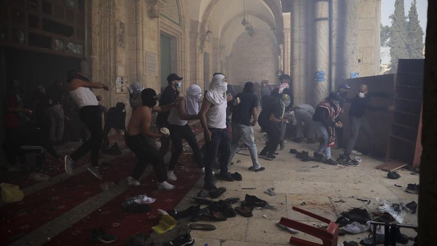 Palestinians clash with Israeli security forces at the Al Aqsa Mosque compound in Jerusalem's Old City Monday, May 10, 2021. Israeli police clashed with Palestinian protesters at a flashpoint Jerusalem holy site on Monday, the latest in a series of confrontations that is pushing the contested city to the brink of eruption. Palestinian medics said at least 180 Palestinians were hurt in the violence at the Al-Aqsa Mosque compound, including 80 who were hospitalized. (AP Photo/Mahmoud Illean)