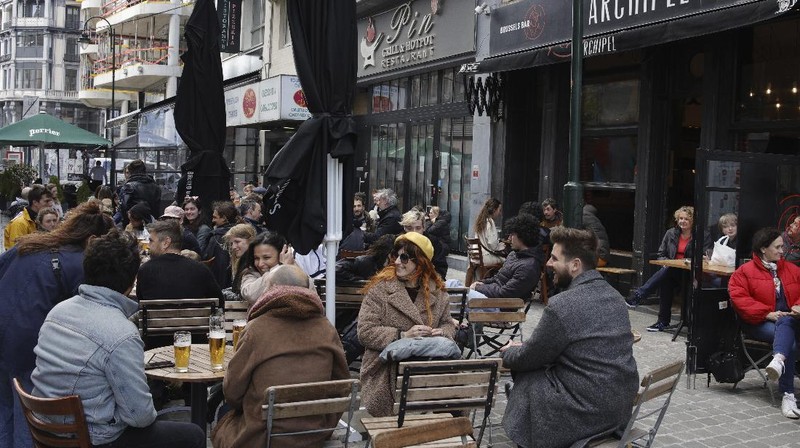 People enjoy drinks at an outdoor cafe in the center of Brussels, Saturday, May 8, 2021. Amid encouraging signs that the latest COVID-19 surge is on the wane, Belgians were celebrating a series of relaxation measures Saturday, including bars and restaurants being allowed to open their terraces again to customers. (AP Photo/Olivier Matthys)