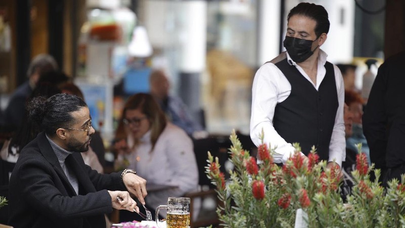 People enjoy drinks at an outdoor cafe in the center of Brussels, Saturday, May 8, 2021. Amid encouraging signs that the latest COVID-19 surge is on the wane, Belgians were celebrating a series of relaxation measures Saturday, including bars and restaurants being allowed to open their terraces again to customers. (AP Photo/Olivier Matthys)