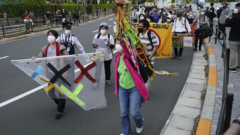 People who are against the Tokyo 2020 Olympics set to open in July, march to protest around Tokyo's National Stadium during an anti-Olympics demonstration Sunday, May 9, 2021. (AP Photo/Eugene Hoshiko)