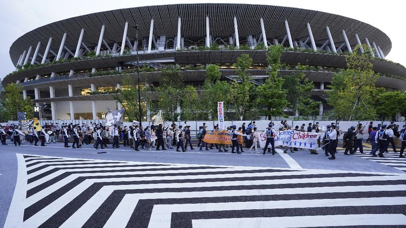 People who are against the Tokyo 2020 Olympics set to open in July, march to protest around Tokyo's National Stadium during an anti-Olympics demonstration Sunday, May 9, 2021. (AP Photo/Eugene Hoshiko)