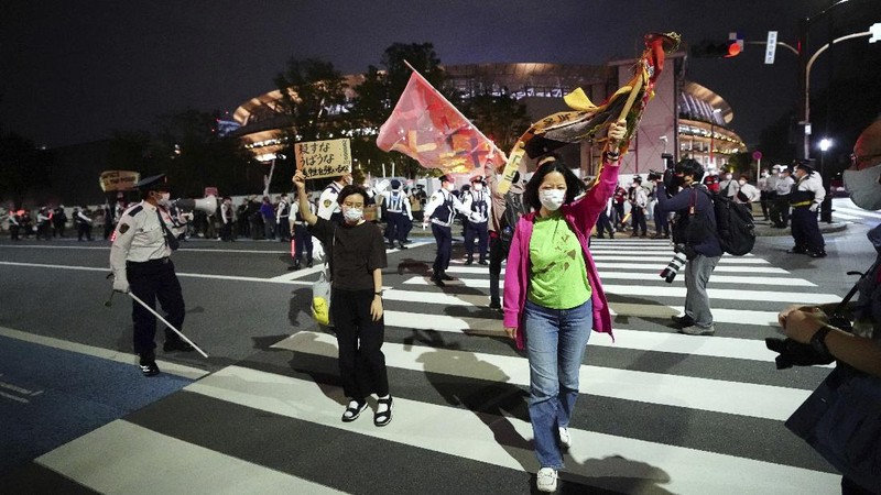 People who are against the Tokyo 2020 Olympics set to open in July, march to protest around Tokyo's National Stadium during an anti-Olympics demonstration Sunday, May 9, 2021. (AP Photo/Eugene Hoshiko)