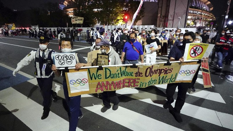 People who are against the Tokyo 2020 Olympics set to open in July, march to protest around Tokyo's National Stadium during an anti-Olympics demonstration Sunday, May 9, 2021. (AP Photo/Eugene Hoshiko)