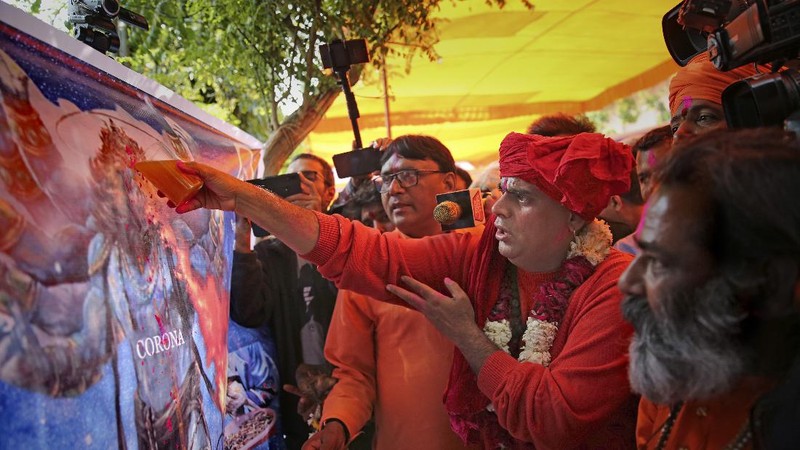 National president of Akhil Bhartiya Hindu Mahasabha Swami Chakrapani Maharaj drinks cow urine during an event organized by a Hindu religious group to promote consumption of cow urine as a cure for the new coronavirus in New Delhi, India, Saturday, March 14, 2020. The vast majority of people recover from the new coronavirus. According to the World Health Organization, people with mild illness recover in about two weeks, while those with more severe illness may take three to six weeks to recover. (AP Photo/Altaf Qadri)