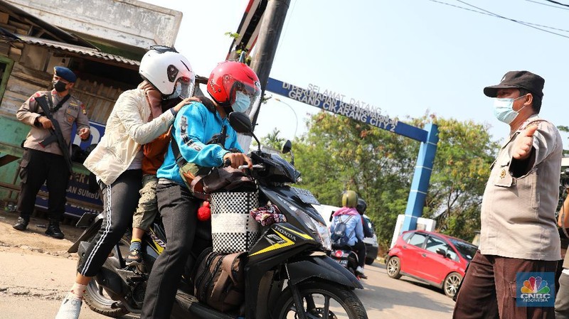 Petugas memeriksa dokumen pengendara motor di pos penyekatan, Jalur Pantura Kedungwaringin, perbatasan Kabupaten Bekasi-Karawang, Senin (10/5/2021).  Dari data yang didpat dari  jam 8.00 wib hingga 12.00 wib sebayak 415 kendaraan yang terdiri dari 342 kendaraan roda dua, 69 kendaraan roda empat, 2 travel dan 2 pickup telah di putar balik. (CNBC Indonesia/Andrean Kristianto)