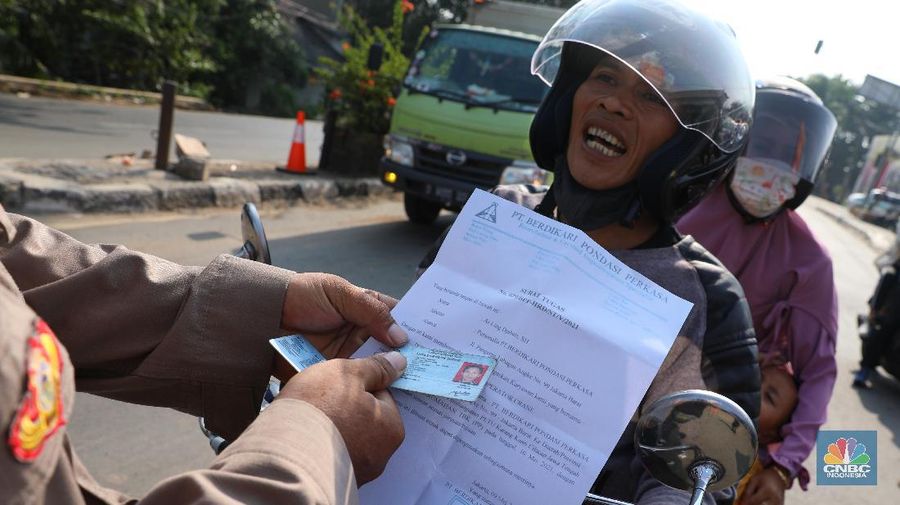Petugas memeriksa dokumen pengendara motor di pos penyekatan, Jalur Pantura Kedungwaringin, perbatasan Kabupaten Bekasi-Karawang, Senin (10/5/2021).  Dari data yang didpat dari  jam 8.00 wib hingga 12.00 wib sebayak 415 kendaraan yang terdiri dari 342 kendaraan roda dua, 69 kendaraan roda empat, 2 travel dan 2 pickup telah di putar balik. (CNBC Indonesia/Andrean Kristianto)