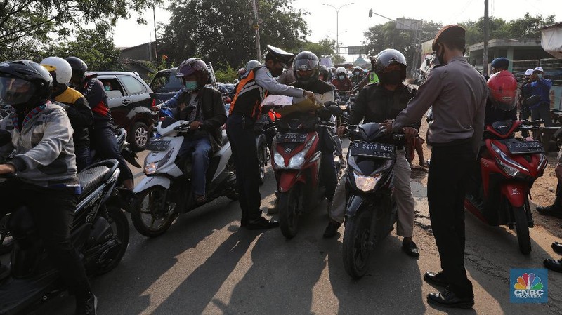 Petugas memeriksa dokumen pengendara motor di pos penyekatan, Jalur Pantura Kedungwaringin, perbatasan Kabupaten Bekasi-Karawang, Senin (10/5/2021).  Dari data yang didpat dari  jam 8.00 wib hingga 12.00 wib sebayak 415 kendaraan yang terdiri dari 342 kendaraan roda dua, 69 kendaraan roda empat, 2 travel dan 2 pickup telah di putar balik. (CNBC Indonesia/Andrean Kristianto)