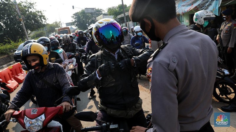 Petugas memeriksa dokumen pengendara motor di pos penyekatan, Jalur Pantura Kedungwaringin, perbatasan Kabupaten Bekasi-Karawang, Senin (10/5/2021).  Dari data yang didpat dari  jam 8.00 wib hingga 12.00 wib sebayak 415 kendaraan yang terdiri dari 342 kendaraan roda dua, 69 kendaraan roda empat, 2 travel dan 2 pickup telah di putar balik. (CNBC Indonesia/Andrean Kristianto)