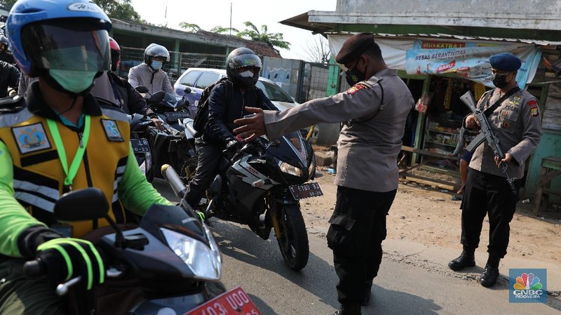 Petugas memeriksa dokumen pengendara motor di pos penyekatan, Jalur Pantura Kedungwaringin, perbatasan Kabupaten Bekasi-Karawang, Senin (10/5/2021).  Dari data yang didpat dari  jam 8.00 wib hingga 12.00 wib sebayak 415 kendaraan yang terdiri dari 342 kendaraan roda dua, 69 kendaraan roda empat, 2 travel dan 2 pickup telah di putar balik. (CNBC Indonesia/Andrean Kristianto)