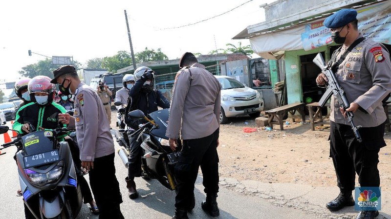 Petugas memeriksa dokumen pengendara motor di pos penyekatan, Jalur Pantura Kedungwaringin, perbatasan Kabupaten Bekasi-Karawang, Senin (10/5/2021).  Dari data yang didpat dari  jam 8.00 wib hingga 12.00 wib sebayak 415 kendaraan yang terdiri dari 342 kendaraan roda dua, 69 kendaraan roda empat, 2 travel dan 2 pickup telah di putar balik. (CNBC Indonesia/Andrean Kristianto)