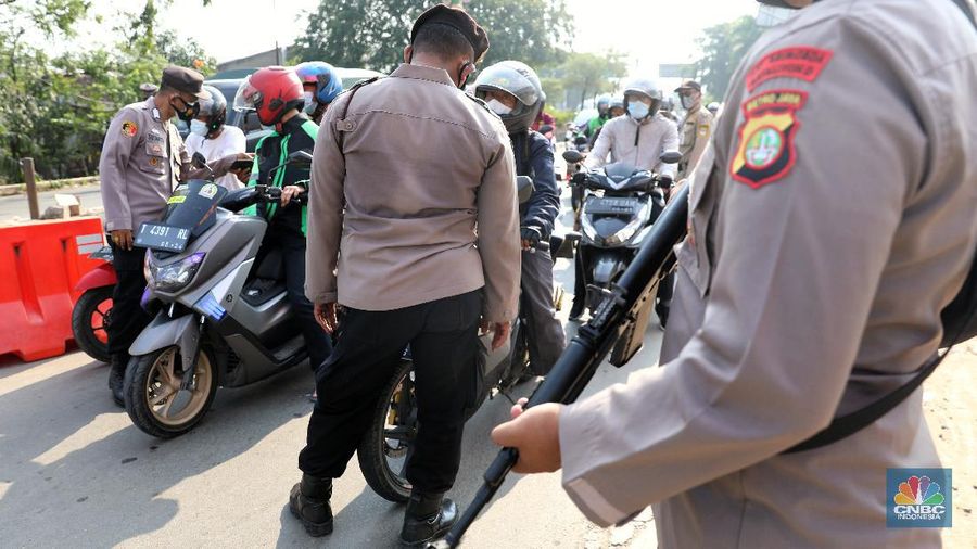 Petugas memeriksa dokumen pengendara motor di pos penyekatan, Jalur Pantura Kedungwaringin, perbatasan Kabupaten Bekasi-Karawang, Senin (10/5/2021).  Dari data yang didpat dari  jam 8.00 wib hingga 12.00 wib sebayak 415 kendaraan yang terdiri dari 342 kendaraan roda dua, 69 kendaraan roda empat, 2 travel dan 2 pickup telah di putar balik. (CNBC Indonesia/Andrean Kristianto)