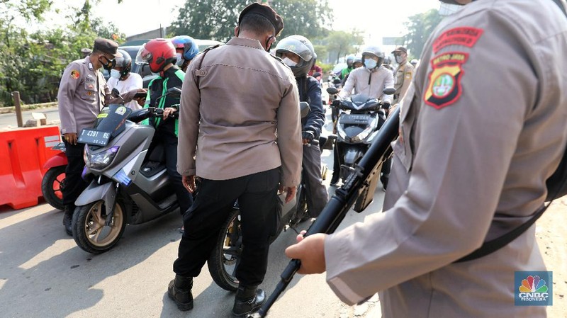 Petugas memeriksa dokumen pengendara motor di pos penyekatan, Jalur Pantura Kedungwaringin, perbatasan Kabupaten Bekasi-Karawang, Senin (10/5/2021).  Dari data yang didpat dari  jam 8.00 wib hingga 12.00 wib sebayak 415 kendaraan yang terdiri dari 342 kendaraan roda dua, 69 kendaraan roda empat, 2 travel dan 2 pickup telah di putar balik. (CNBC Indonesia/Andrean Kristianto)