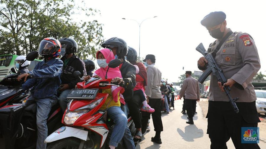 Petugas memeriksa dokumen pengendara motor di pos penyekatan, Jalur Pantura Kedungwaringin, perbatasan Kabupaten Bekasi-Karawang, Senin (10/5/2021). Dari data yang didpat dari jam 8.00 wib hingga 12.00 wib sebayak 415 kendaraan yang terdiri dari 342 kendaraan roda dua, 69 kendaraan roda empat, 2 travel dan 2 pickup telah di putar balik. (CNBC Indonesia/Andrean Kristianto)