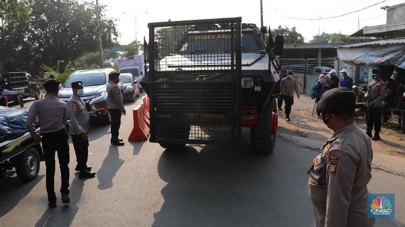 Petugas memeriksa dokumen pengendara motor di pos penyekatan, Jalur Pantura Kedungwaringin, perbatasan Kabupaten Bekasi-Karawang, Senin (10/5/2021).  Dari data yang didpat dari  jam 8.00 wib hingga 12.00 wib sebayak 415 kendaraan yang terdiri dari 342 kendaraan roda dua, 69 kendaraan roda empat, 2 travel dan 2 pickup telah di putar balik. (CNBC Indonesia/Andrean Kristianto)