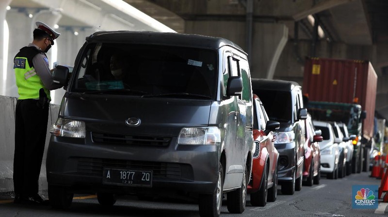 Sejumlah petugas Kepolisian memeriksa dokumen pengendara yang melintas di pos penyekatan pemudik Tol Cikarang Barat, Kabupaten Bekasi, Jawa Barat, Selasa (11/5/2021). Petugas gabungan memperketat pemeriksaan dokumen kendaraan yang melintasi pos penyekatan pemudik jelang H-2 perayaan Hari Raya Idul Fitri 1442 H guna memutus rantai penyebaran wabah COVID-19.  (CNBC Indonesia/Andrean Kristianto)