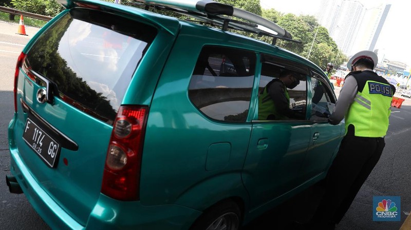 Sejumlah petugas Kepolisian memeriksa dokumen pengendara yang melintas di pos penyekatan pemudik Tol Cikarang Barat, Kabupaten Bekasi, Jawa Barat, Selasa (11/5/2021). Petugas gabungan memperketat pemeriksaan dokumen kendaraan yang melintasi pos penyekatan pemudik jelang H-2 perayaan Hari Raya Idul Fitri 1442 H guna memutus rantai penyebaran wabah COVID-19.  (CNBC Indonesia/Andrean Kristianto)