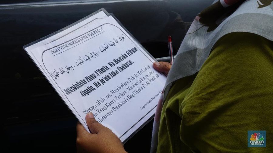 Warga menunaikan zakat fitrah dalam acara ulan suci Ramadan 1442 Hijriah di Gerai Zakat Infaq dan Shodaqoh drive thru di Masjid Nurul Hidayah, Jakarta, Selasa (11/5/2021). (վ/Tri Susilo)