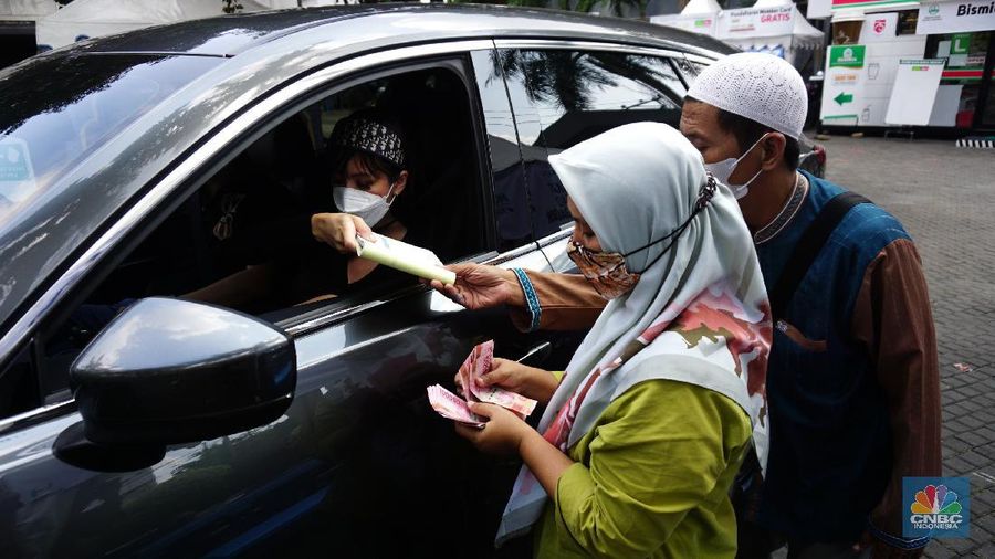 Warga menunaikan zakat fitrah dalam acara ulan suci Ramadan 1442 Hijriah di Gerai Zakat Infaq dan Shodaqoh drive thru di Masjid Nurul Hidayah, Jakarta, Selasa (11/5/2021). (²©²ÊÍøÕ¾/Tri Susilo)