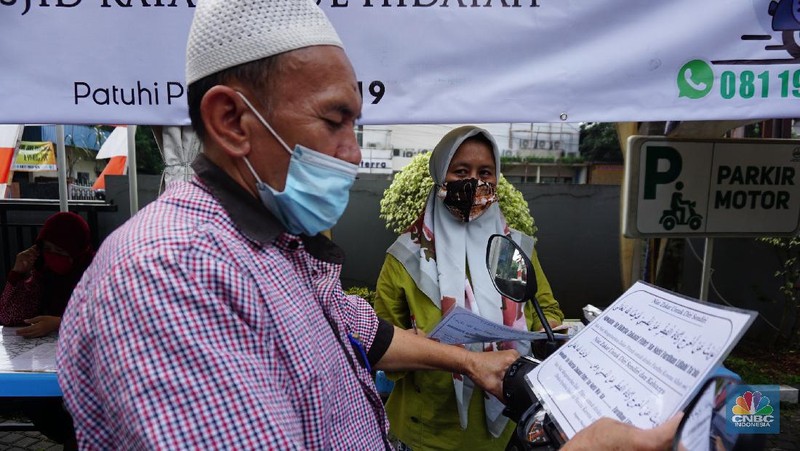 Warga menunaikan zakat fitrah dalam acara ulan suci Ramadan 1442 Hijriah di Gerai Zakat Infaq dan Shodaqoh drive thru di Masjid Nurul Hidayah, Jakarta, Selasa (11/5/2021). (CNBC Indonesia/Tri Susilo)